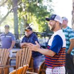 veterans huddled around chairs with a tree in the background