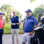 golf prof and veteran golfers by their golf carts prior to a golf round