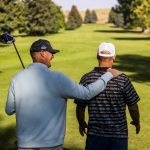 a golf pro and veteran walking side by side down a fairway in buffalo wyoming