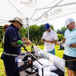 golfers and comedians at the hole heckler hole during a charity golf tournament 