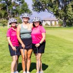 female golfers wearing cow bucket hat and matching shirts at charity golf tournament in Colorado