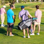 team of four golfers planning their next shot during a charity golf tournament round in Colorado