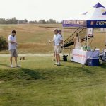 golfers at a sponsor booth on a teebox of a charity golf tournament