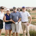 a team of golfers standing together before the round begins at a charity golf tournament in colorado