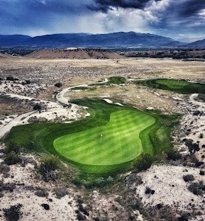aerial view of putting green with mountain in background