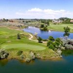 aerial view of golf course green surrounded by water