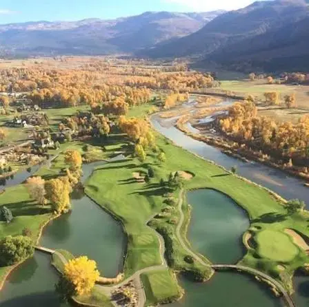 Aerial view of Dalton Ranch Golf Club's fairways along the Animas Valley with red cliffs in the background, Durango, Colorado