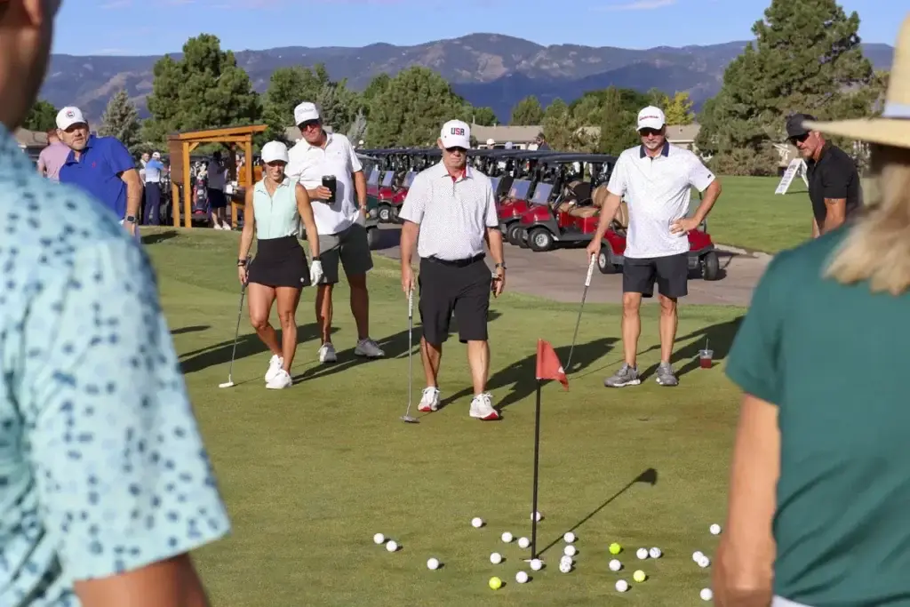 A team of golfers reacting to a shot at a Colorado golf event
