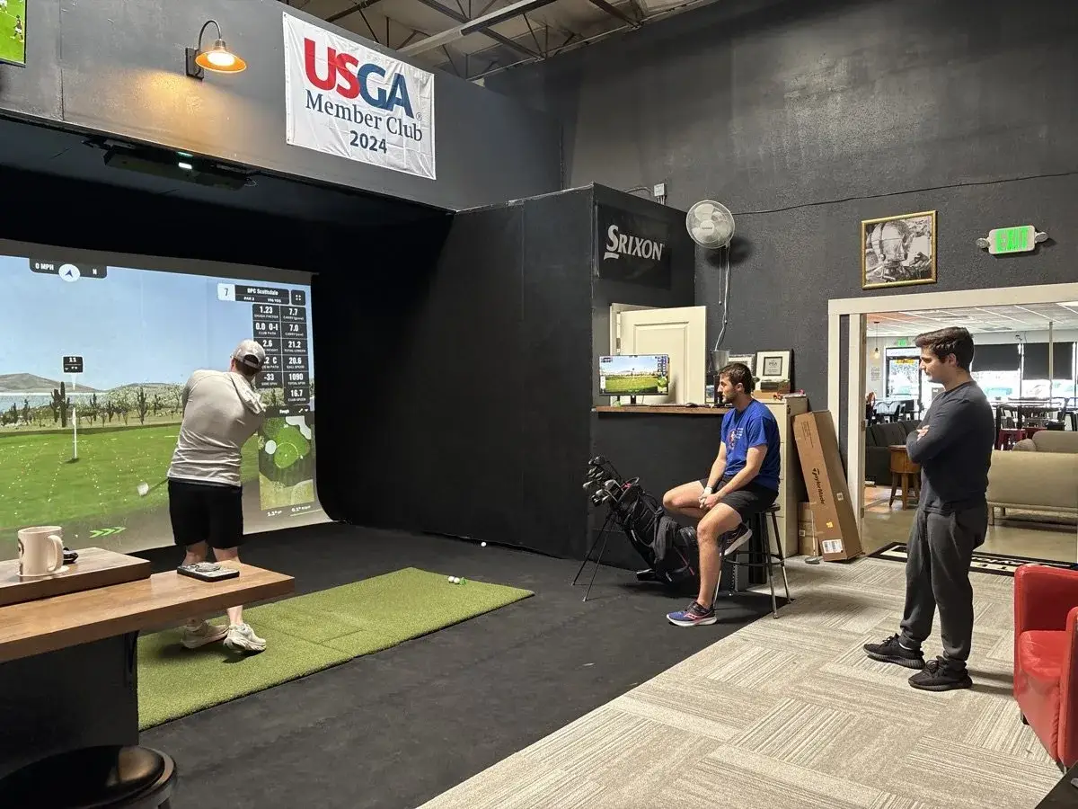 Friends gathered around a Uneekor simulator bay at COR Golf Café & Lounge in Wheat Ridge, Colorado